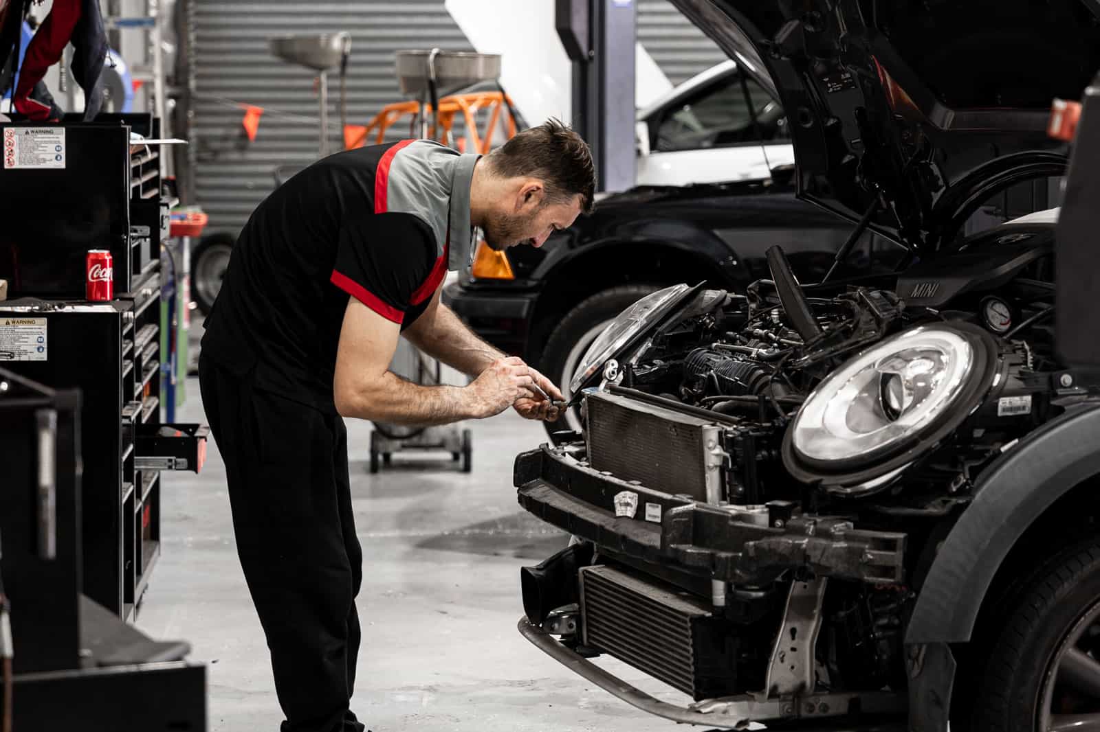 A mechanic working on a car during a European Car Log Book Servicing.