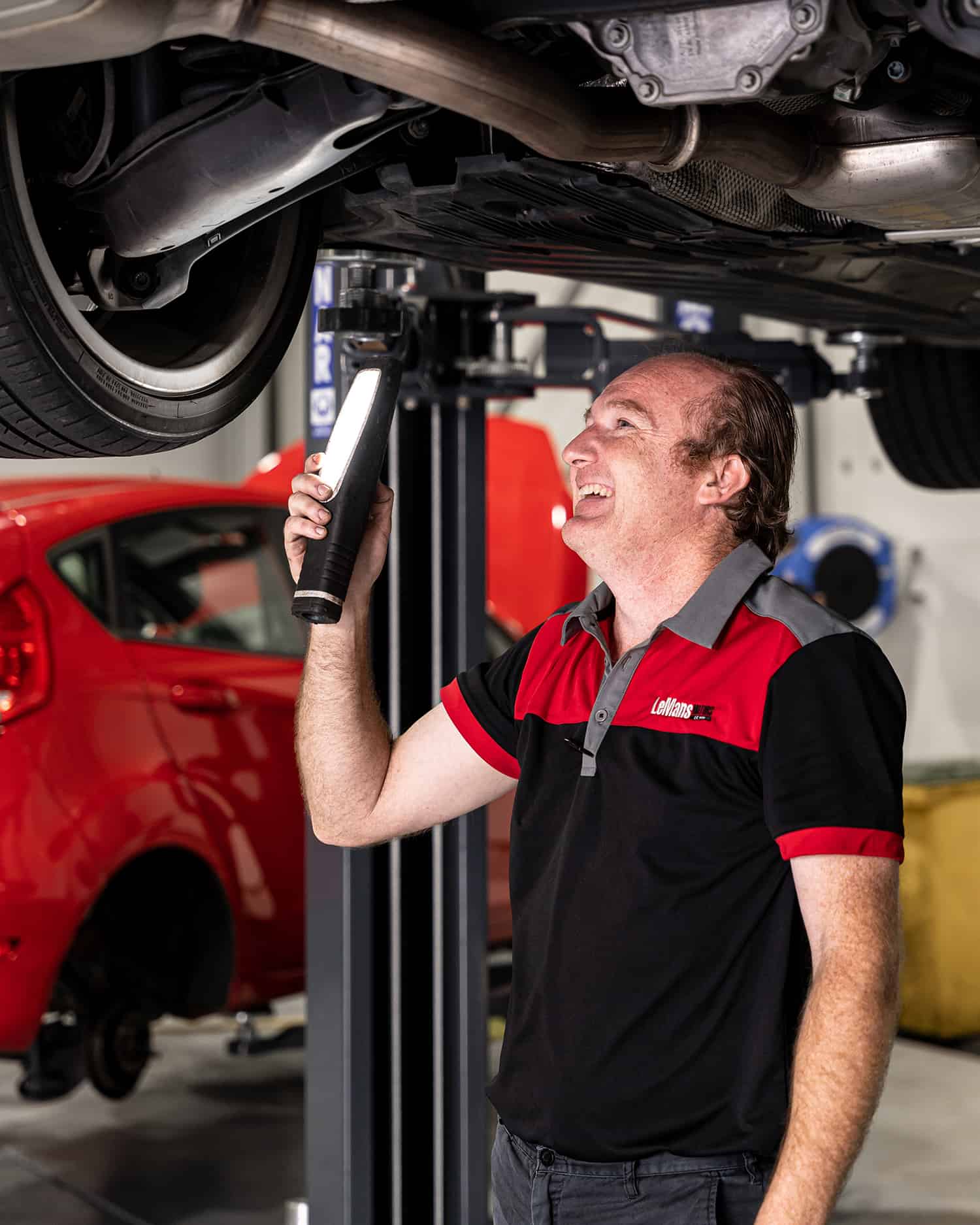 A car mechanic checking the brakes under a car as part European Car Log Book Servicing and European Car Brake Repairs in Brisbane