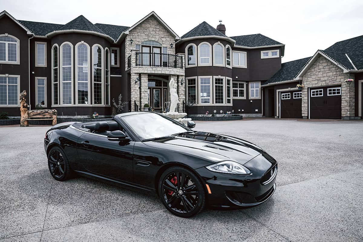 Maserati car in front of a large house