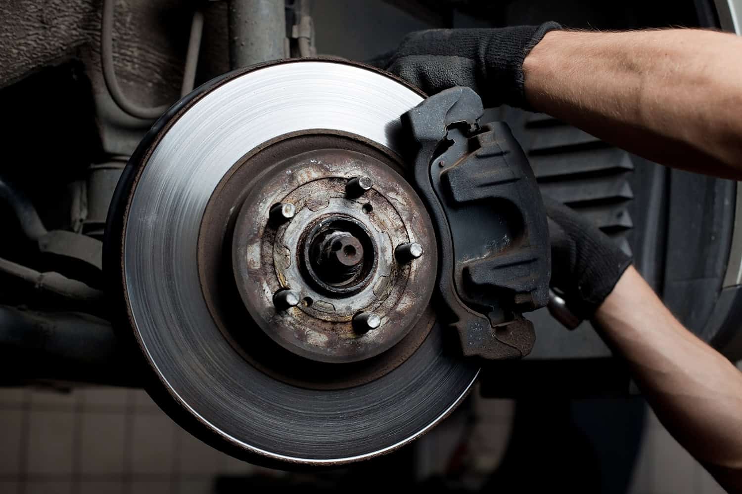 Car mechanic repairing Mercedes brake pads